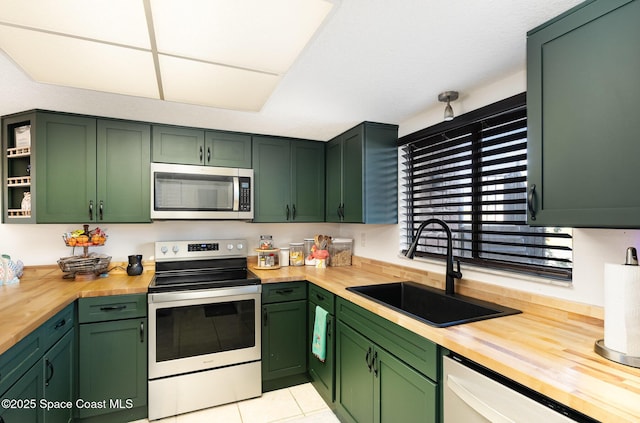 100 Canebreakers Dr Unit 112, Cocoa, FL 32927 - kitchen featuring a sink, wood counters, green cabinets, and stainless steel appliances