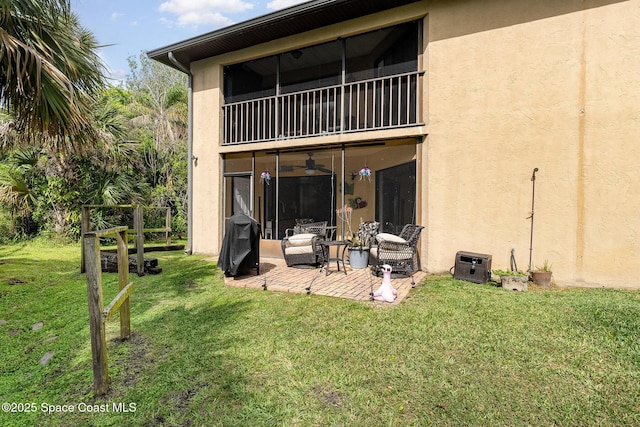 100 Canebreakers Dr Unit 112, Cocoa, FL 32927 - rear view of house with a lawn, a patio, stucco siding, and a balcony