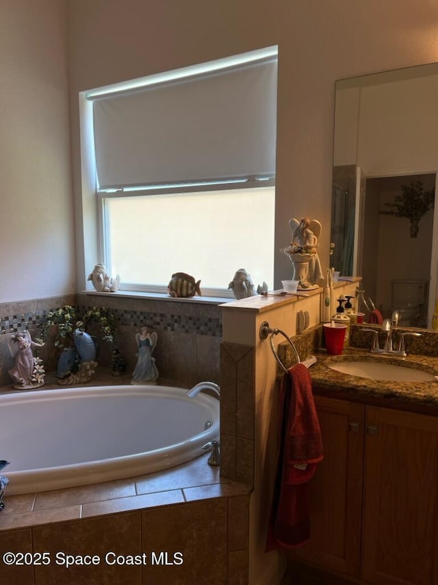 full bath featuring an enclosed shower, a garden tub, and vanity