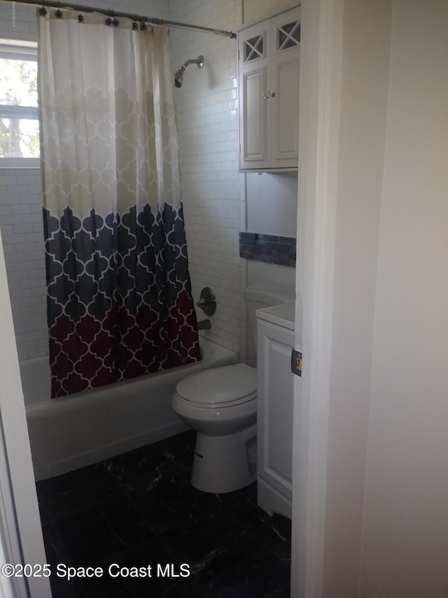 full bathroom with marble finish floor, shower / bath combination with curtain, and toilet
