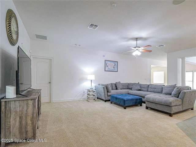 living room featuring visible vents, baseboards, ceiling fan, and light carpet