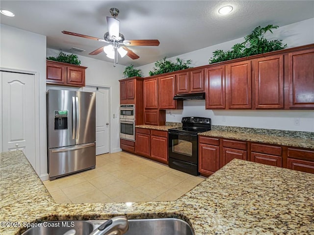 kitchen with reddish brown cabinets, recessed lighting, under cabinet range hood, a ceiling fan, and appliances with stainless steel finishes