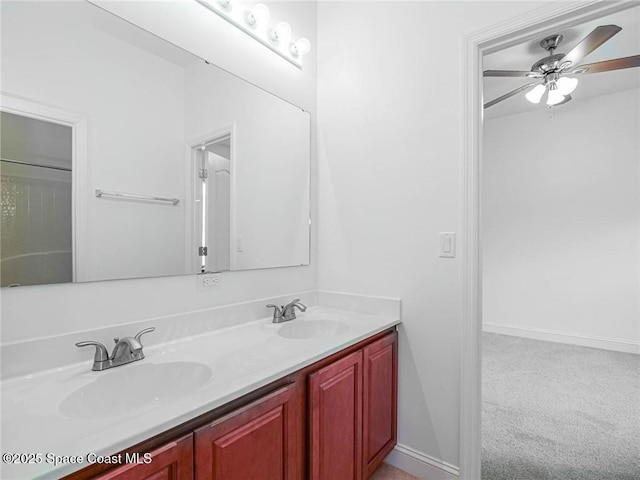 bathroom with a sink, baseboards, ceiling fan, and double vanity