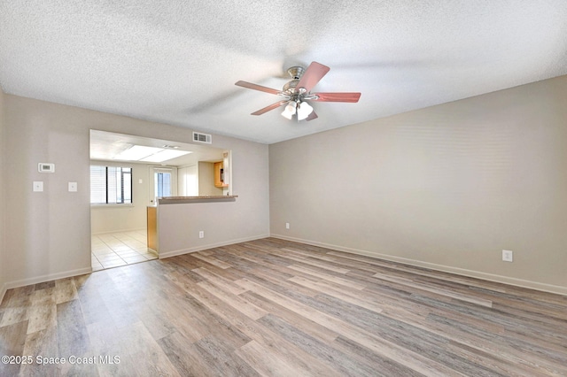 1515 N Huntington Ln Unit 415, Rockledge, FL 32955 - empty room featuring visible vents, baseboards, a textured ceiling, a ceiling fan, and light wood finished floors
