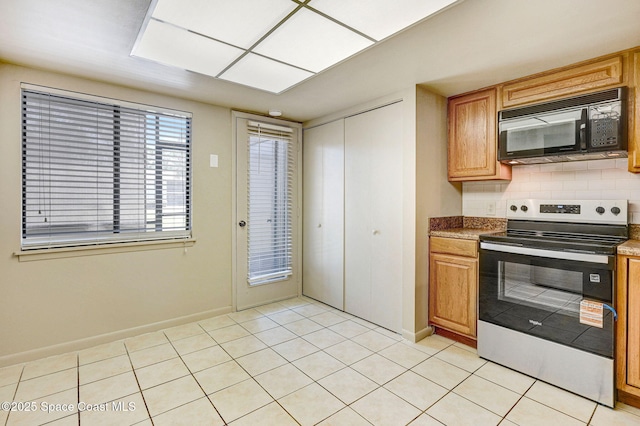 1515 N Huntington Ln Unit 415, Rockledge, FL 32955 - kitchen with black microwave, baseboards, light tile patterned floors, and stainless steel electric range