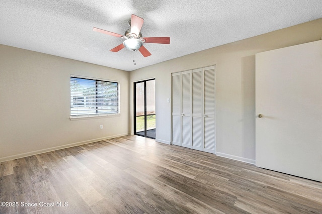 1515 N Huntington Ln Unit 415, Rockledge, FL 32955 - unfurnished bedroom with wood finished floors, two closets, baseboards, ceiling fan, and a textured ceiling