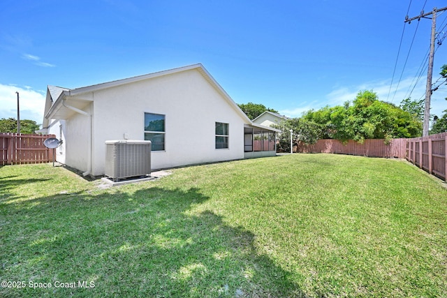 view of yard featuring a fenced backyard, central AC unit, and a sunroom