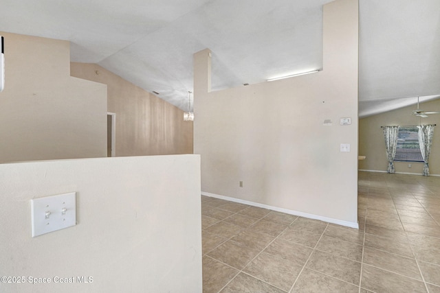 tiled empty room featuring baseboards, a ceiling fan, and vaulted ceiling
