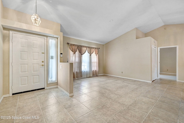 entrance foyer featuring baseboards, light tile patterned floors, and vaulted ceiling