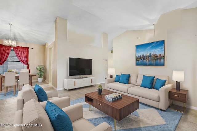 living room featuring baseboards, wood finished floors, a chandelier, and vaulted ceiling