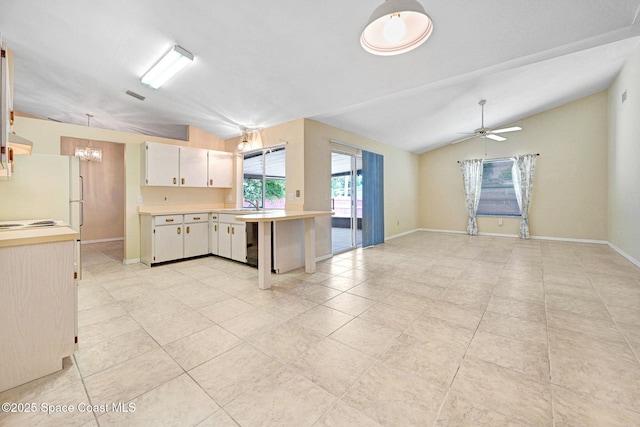 kitchen with light countertops, baseboards, light tile patterned floors, and ceiling fan with notable chandelier