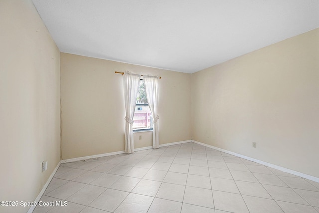 unfurnished room featuring light tile patterned floors and baseboards