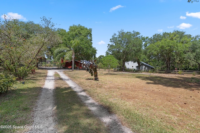 view of street with a rural view, driveway, and a gated entry