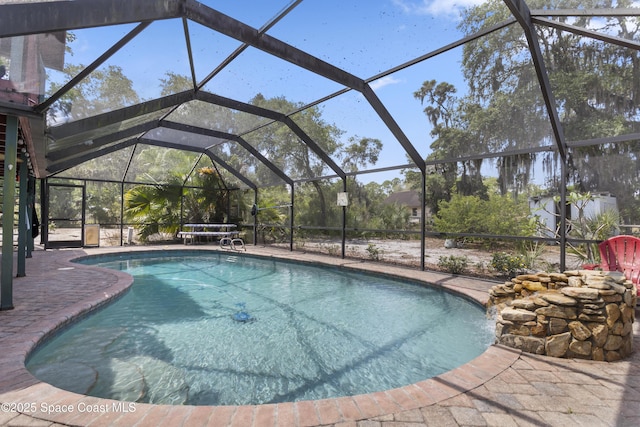 pool with glass enclosure and a patio area