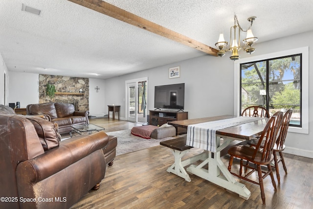 dining room featuring a textured ceiling, plenty of natural light, and wood finished floors
