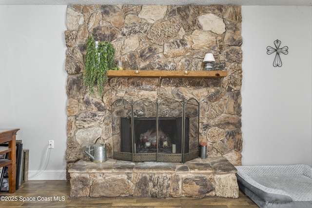 interior details with baseboards, wood finished floors, and a fireplace