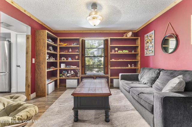 living room featuring visible vents, a textured ceiling, and wood finished floors