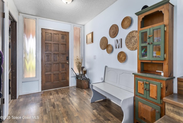 foyer entrance featuring a textured ceiling and wood finished floors