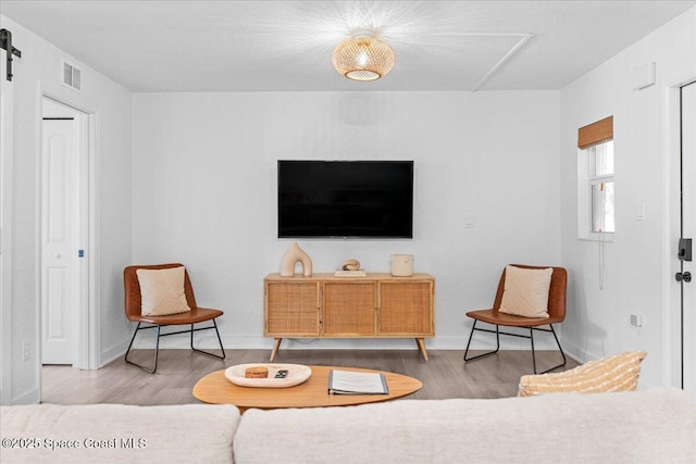 299 E Central Blvd Unit 6, Cape Canaveral, FL 32920 - interior space featuring baseboards, visible vents, a barn door, and wood finished floors