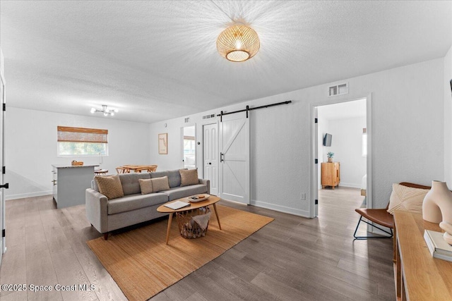 299 E Central Blvd Unit 6, Cape Canaveral, FL 32920 - living area featuring visible vents, wood finished floors, baseboards, a barn door, and a textured ceiling