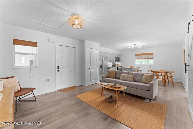 299 E Central Blvd Unit 6, Cape Canaveral, FL 32920 - living room featuring baseboards, light wood finished floors, and a textured ceiling