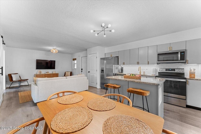 299 E Central Blvd Unit 6, Cape Canaveral, FL 32920 - dining room featuring an inviting chandelier, light wood-type flooring, and a textured ceiling