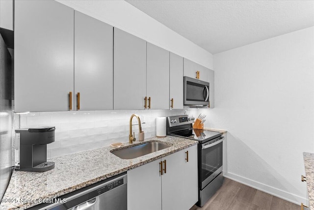 299 E Central Blvd Unit 6, Cape Canaveral, FL 32920 - kitchen featuring dark wood-style flooring, light stone counters, a sink, stainless steel appliances, and backsplash