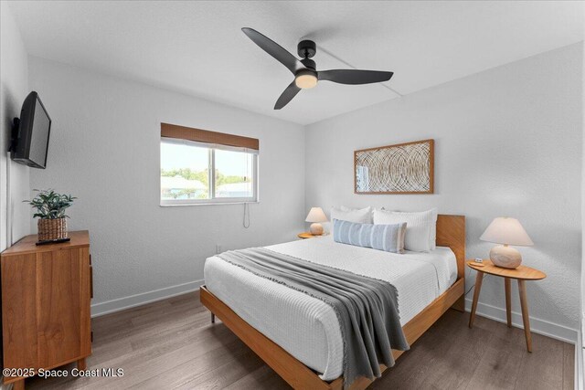 299 E Central Blvd Unit 6, Cape Canaveral, FL 32920 - bedroom with baseboards, ceiling fan, and wood finished floors