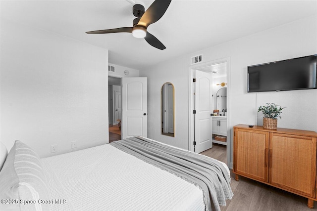 299 E Central Blvd Unit 6, Cape Canaveral, FL 32920 - bedroom with a ceiling fan, connected bathroom, wood finished floors, and visible vents