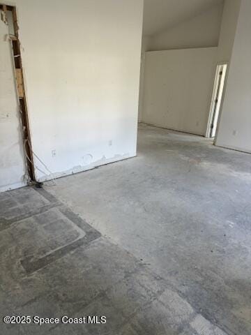 interior space featuring concrete flooring and lofted ceiling