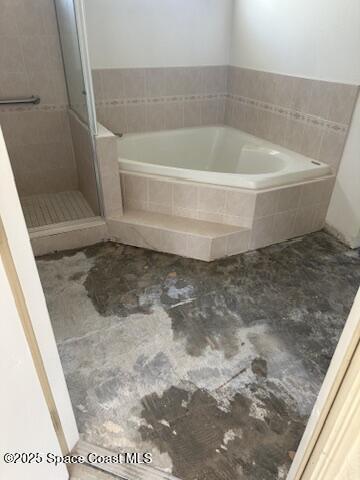 full bathroom with a shower stall and a bath