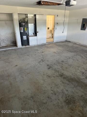garage featuring electric panel, a garage door opener, and electric water heater