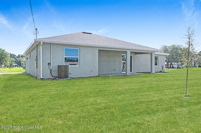 1401 Wyoming Dr SE, Palm Bay, FL 32909 - rear view of house featuring central AC, a shingled roof, stucco siding, and a yard