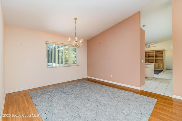 1523 Tippicanoe Ct, Melbourne, FL 32940 - unfurnished room featuring baseboards, light wood finished floors, high vaulted ceiling, and ceiling fan with notable chandelier