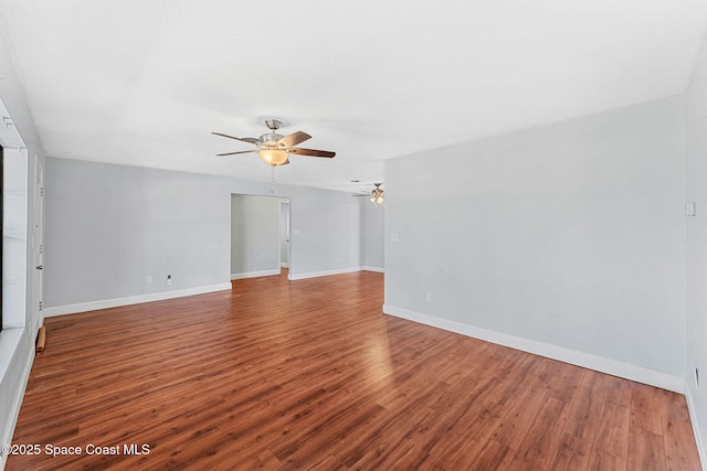 empty room with baseboards, a ceiling fan, and wood finished floors
