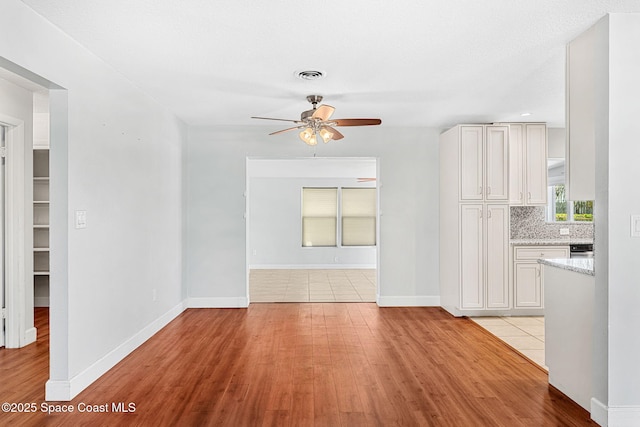 unfurnished living room with light wood-style floors, a ceiling fan, and visible vents