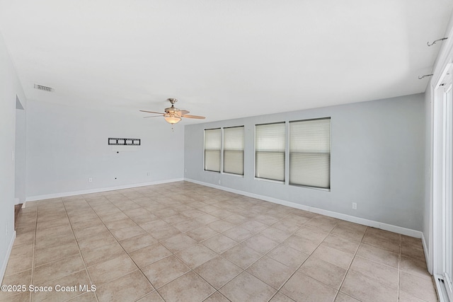 unfurnished room with a ceiling fan, baseboards, visible vents, and light tile patterned floors