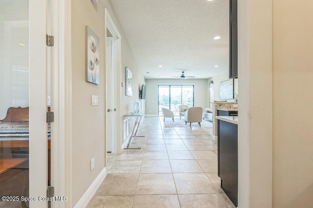 7447 Bluemink Ln, Melbourne, FL 32940 - corridor with a textured ceiling, light tile patterned floors, baseboards, and recessed lighting