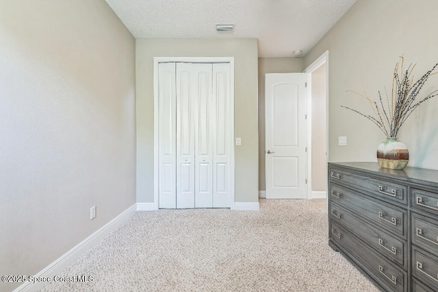 7447 Bluemink Ln, Melbourne, FL 32940 - bedroom featuring a closet, baseboards, a textured ceiling, and carpet flooring