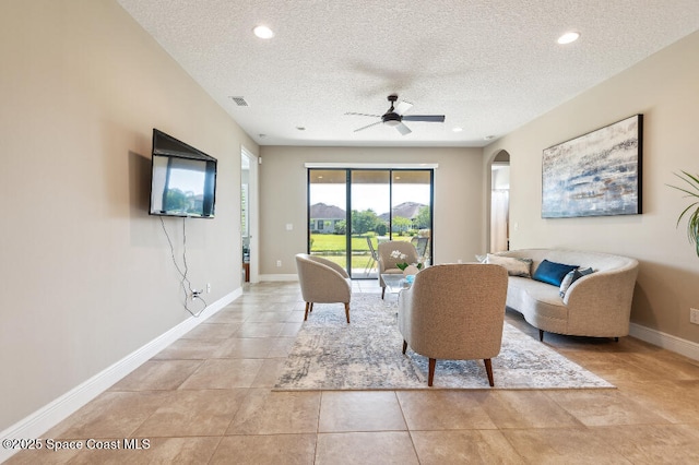 7447 Bluemink Ln, Melbourne, FL 32940 - living room featuring a textured ceiling, arched walkways, a ceiling fan, recessed lighting, and baseboards