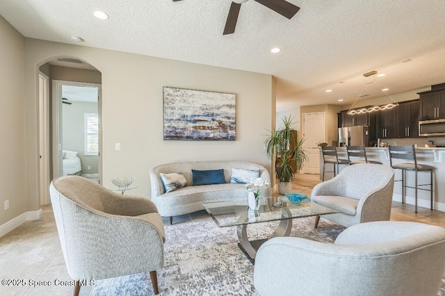 7447 Bluemink Ln, Melbourne, FL 32940 - living room with a ceiling fan, a textured ceiling, arched walkways, recessed lighting, and baseboards