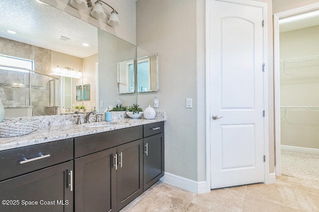 7447 Bluemink Ln, Melbourne, FL 32940 - bathroom featuring baseboards, a shower stall, vanity, and a spacious closet