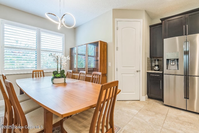 7447 Bluemink Ln, Melbourne, FL 32940 - dining room with healthy amount of natural light, light tile patterned floors, a chandelier, and a textured ceiling