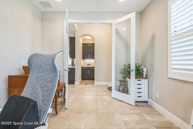 7447 Bluemink Ln, Melbourne, FL 32940 - living area featuring baseboards, light tile patterned floors, arched walkways, and recessed lighting
