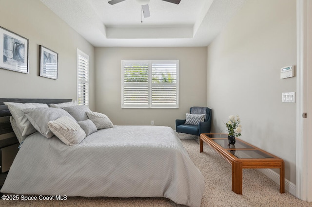 7447 Bluemink Ln, Melbourne, FL 32940 - bedroom with carpet, a tray ceiling, baseboards, and ceiling fan