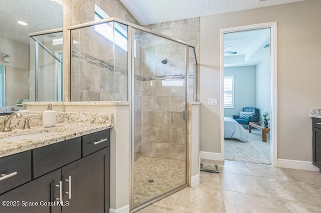 7447 Bluemink Ln, Melbourne, FL 32940 - bathroom with a textured ceiling, a shower stall, vanity, baseboards, and tile patterned floors