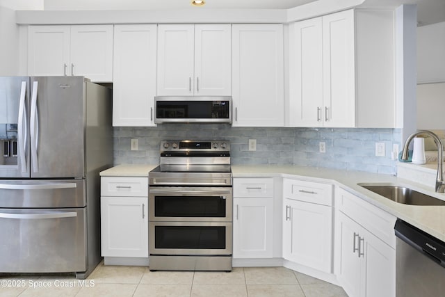kitchen featuring a sink, light countertops, stainless steel appliances, white cabinetry, and light tile patterned floors