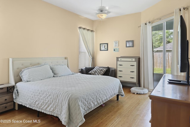 bedroom with wood finished floors and access to exterior