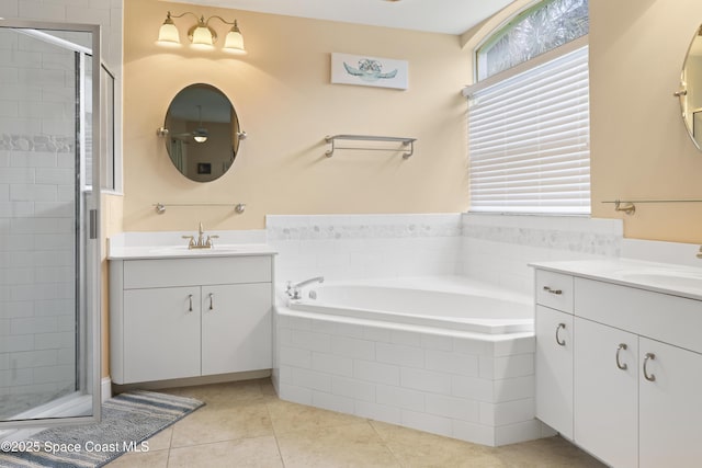 full bath featuring a sink, a stall shower, a garden tub, and two vanities