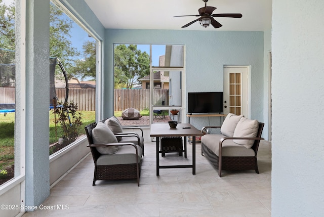 sunroom / solarium with a ceiling fan and an outdoor living space